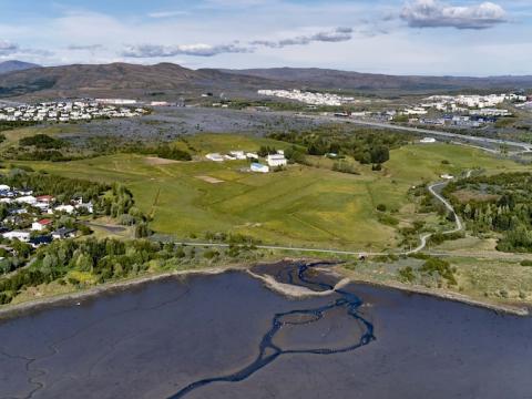Aerial photo showing Keldur area, sea, grass, trees, buildings.