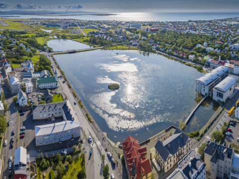 Séð yfir Tjörnina og Ráðhús Reykjavíkur í sól og góðu veðri