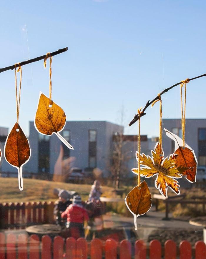 Artwork made from leaves in a window at Rauðhóll Preschool