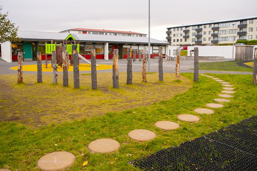 Wooden posts and playground equipment on the grounds of Bakkaborg.