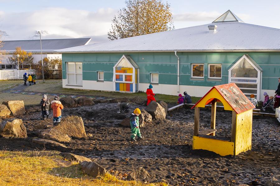 Children in the sandbox and playground equipment on the Engjaborg grounds.