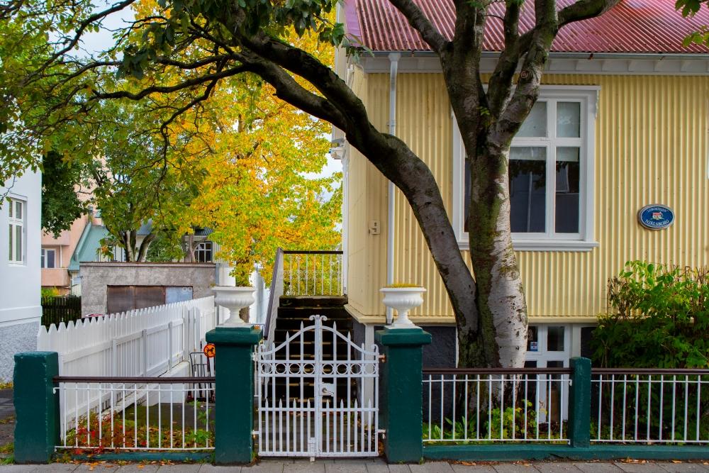 Gult hús með hvítri girðingu sem hýsir leikskólann Miðborg - Njálsborg