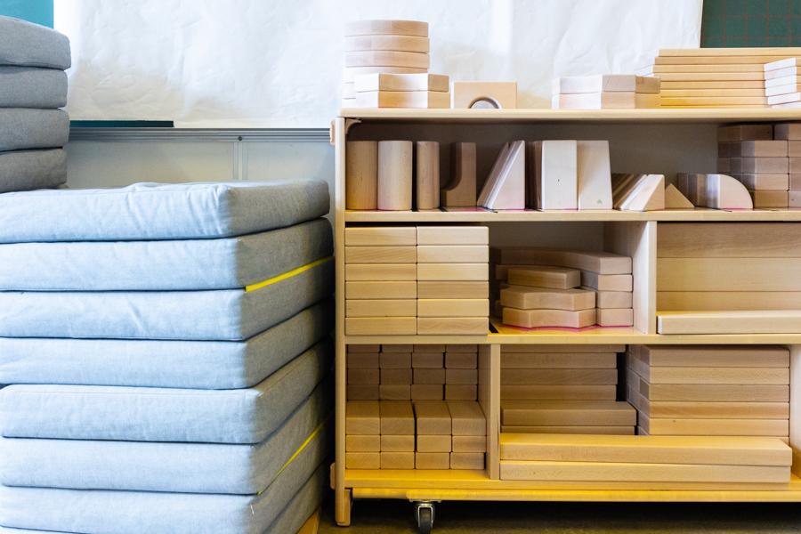 Mattresses in a stack and a shelf with wooden blocks.