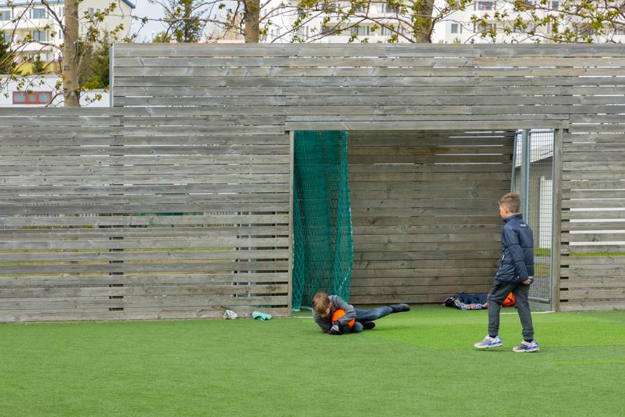 Children playing soccer on an outdoor grass field.