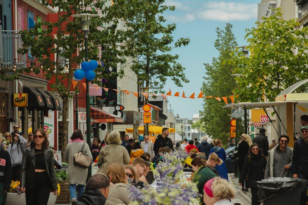 Crowd on Laugavegur street where a long table has been set up in the middle of the street
