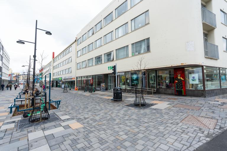 Hlemmur.Haus. Photo taken at an angle toward the building, white sky, with the sidewalk in the foreground.