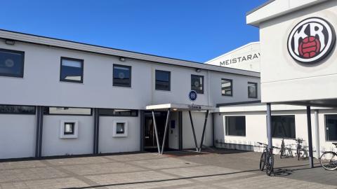 Ljósmynd af hvítu húsi með skilti sem á stendur Tjörnin. Stórt KR merki á hægri hlið hússins. 