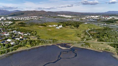 Aerial photo showing Keldur area, sea, grass, trees, buildings.