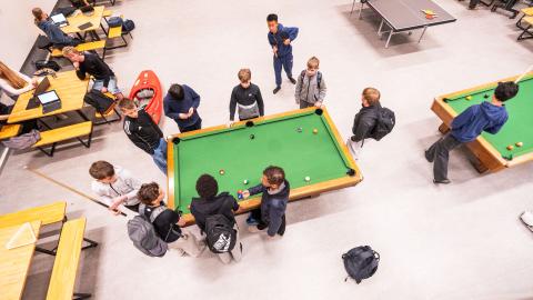 Unglingar í frímínútum í Ölduselsskóla, tekið ofan á þau að spila pool á grænu borði